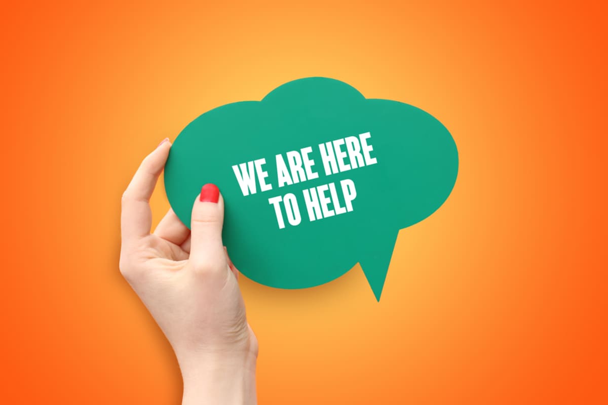 A hand holding We Are Here to Help, Geekly Media property management marketing experts concept