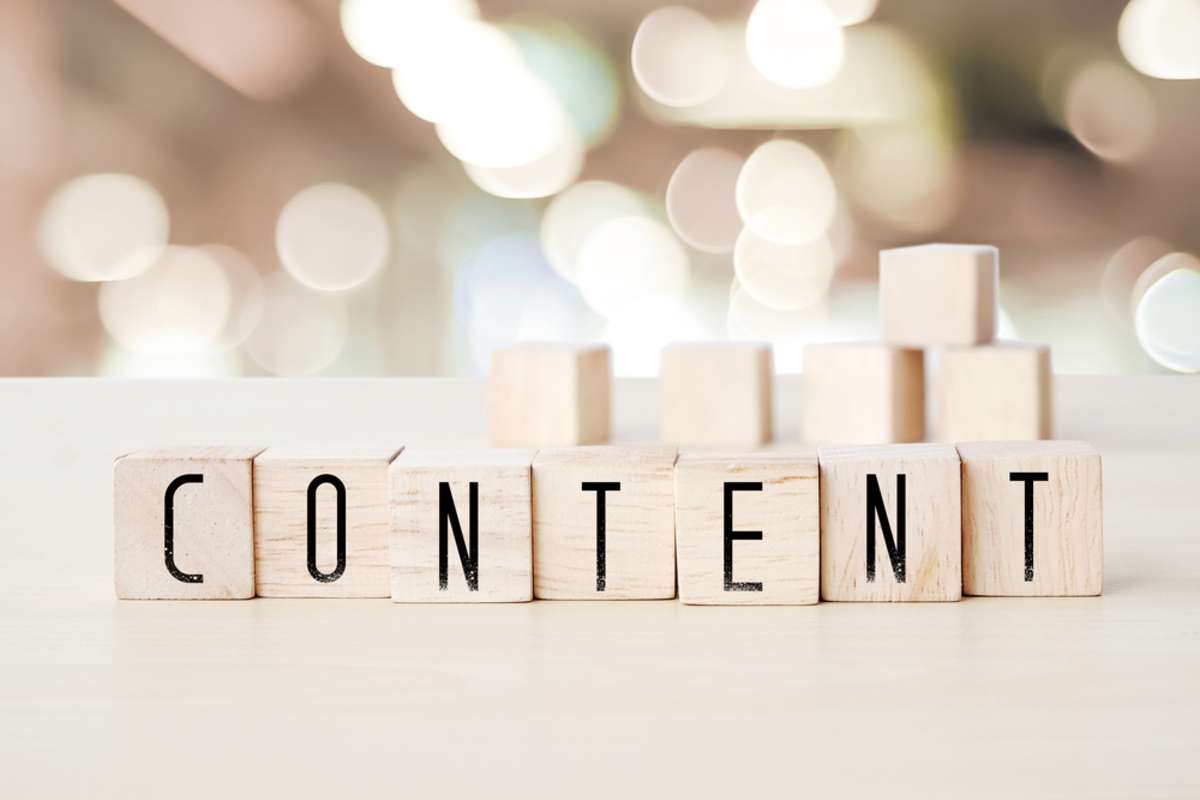 The word content spelled in wooden blocks represent the expertise of a content marketing agency